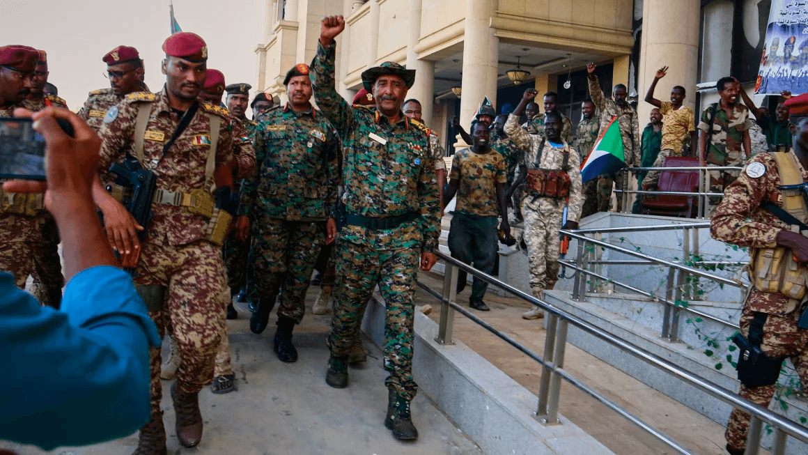 Sudan's military chief Gen. Abdel-Fattah Burhan, center, is greeted by troops as he arrives at the Republican Palace in Khartoum, Sudan, on Wednesday.